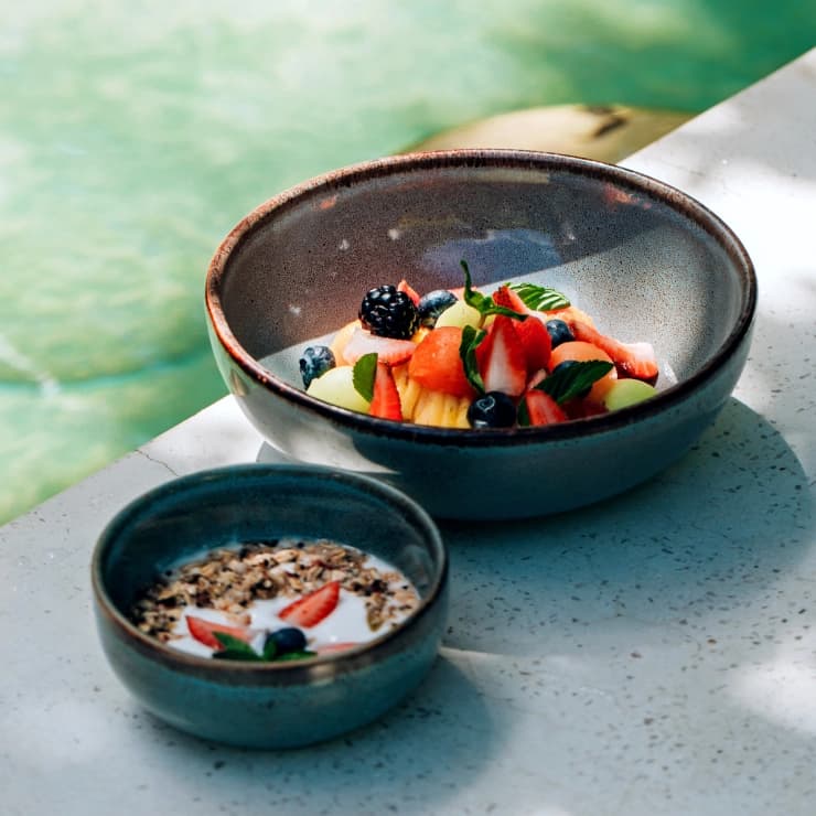 A dish at Orquidea: beetroot risotto with mushrooms, watermelon radish and an edible flower, in a glazed clay bowl